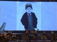 2014年，朝鲜中央电视台播出庆祝朝鲜人民军首届飞行员大会的牡丹峰乐团演出影像，金正恩幼年时期照片作为背景投影在舞台上。照片中的金正恩身穿军装神气十足。