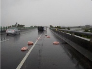 11日上午11时，台湾嘉义县一小货车因雨天路滑自撞护栏侧翻倒在快车道，满车猪肉片散了一地，送货驾驶以为自己受困，竟盘坐车内跟老板通电话报告车祸状况，附近国道工程人员到场，担心遭后车追撞劝它离开，他才发现车门可打开，在旁人协助下爬出货车就医。