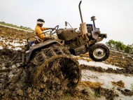 2016年7月27日，印度维杰亚瓦达，当地农民驾驶拖拉机在犁洪水冲刷过的田地。拖拉机的后轮是用重达三吨的金属制成，因为普通的橡胶轮胎容易陷在泥里。这项工作极考验技巧，也十分危险，已有数人因拖拉机倾翻丧命。这种犁地技巧在当地已经流行多年，特别是在雨季来临时。 
