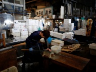 在东京筑地鱼市，一名男子正在磨一把特制的金枪鱼刀。 