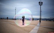 当地时间2014年11月18日，葡萄牙里斯本，一名游客正在拍照，从远处看，她仿佛置身泡泡中。