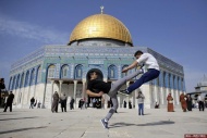 2014年11月14日,在耶路撒冷老城岩石圆顶前,巴勒斯坦青年在练习跑酷技巧。
