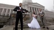 The best man in a wedding party holds an AR-10 rifle while the party was having its pre-wedding portraits taken on the steps of the state capitol in Olympia, Washington, on Saturday, December 13. The man was handed the gun by activist Brandon Lyons, who was participating in a protest against the state's new law that requires background checks on all gun sales and transfers, including private transactions. The wedding party, which declined to be identified, was not part of the protest.