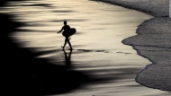 A surfer makes his way out of the water Monday, December 15, at Zurriola Beach in San Sebastian, Spain.