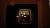 A museum staff member checks the lighting near the &quot;Earlier Mona Lisa&quot; before the painting went on exhibition at The Arts House in Singapore. A private Swiss art foundation says the painting was done by Leonardo da Vinci years before his &quot;Mona Lisa&quot; masterpiece.