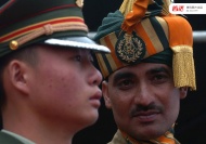 一名中国边防武警（左）和一位印度边防军人在中印边境两侧站岗。